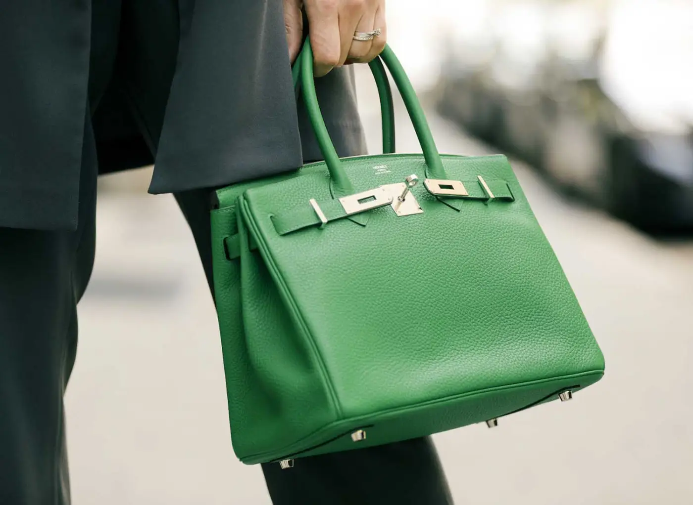 Sac à main de luxe en cuir grainé, anses et fermoir, porté en ville